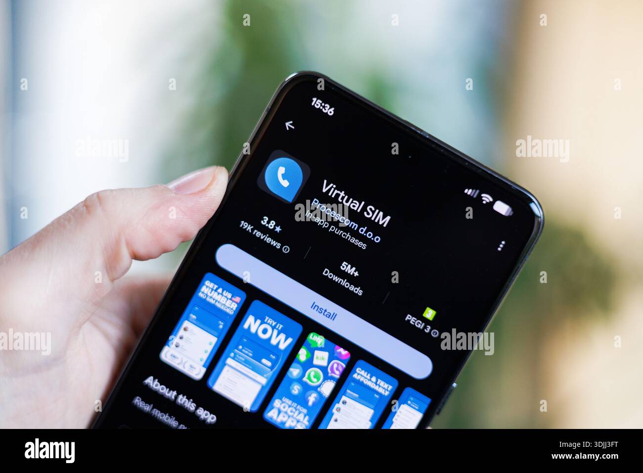 Phone in hand displaying Virtual SIM Card app on Google Play Store Stock Photo