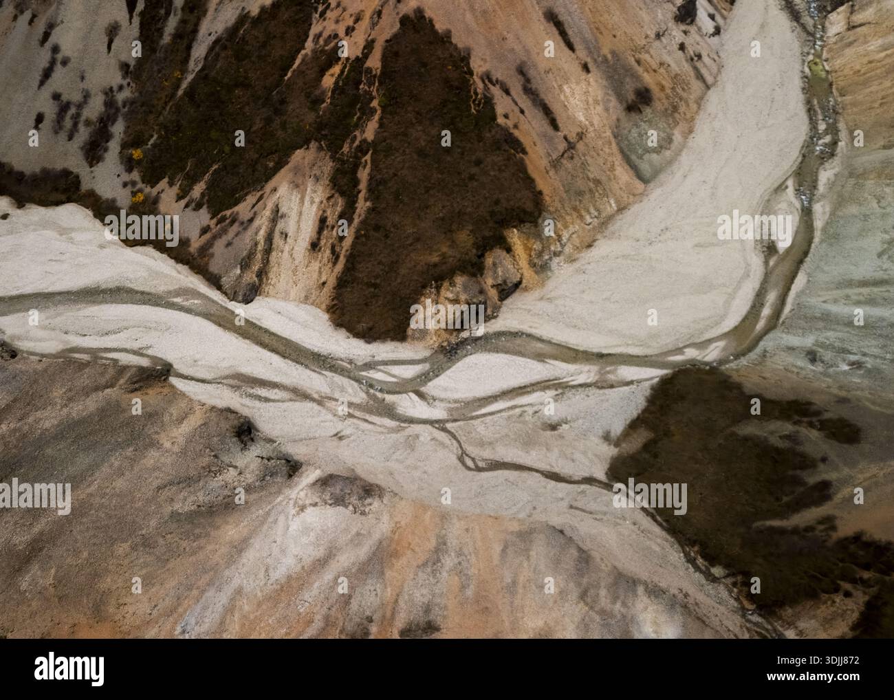 Aerial view of a braided river system carves through a landscape of ...