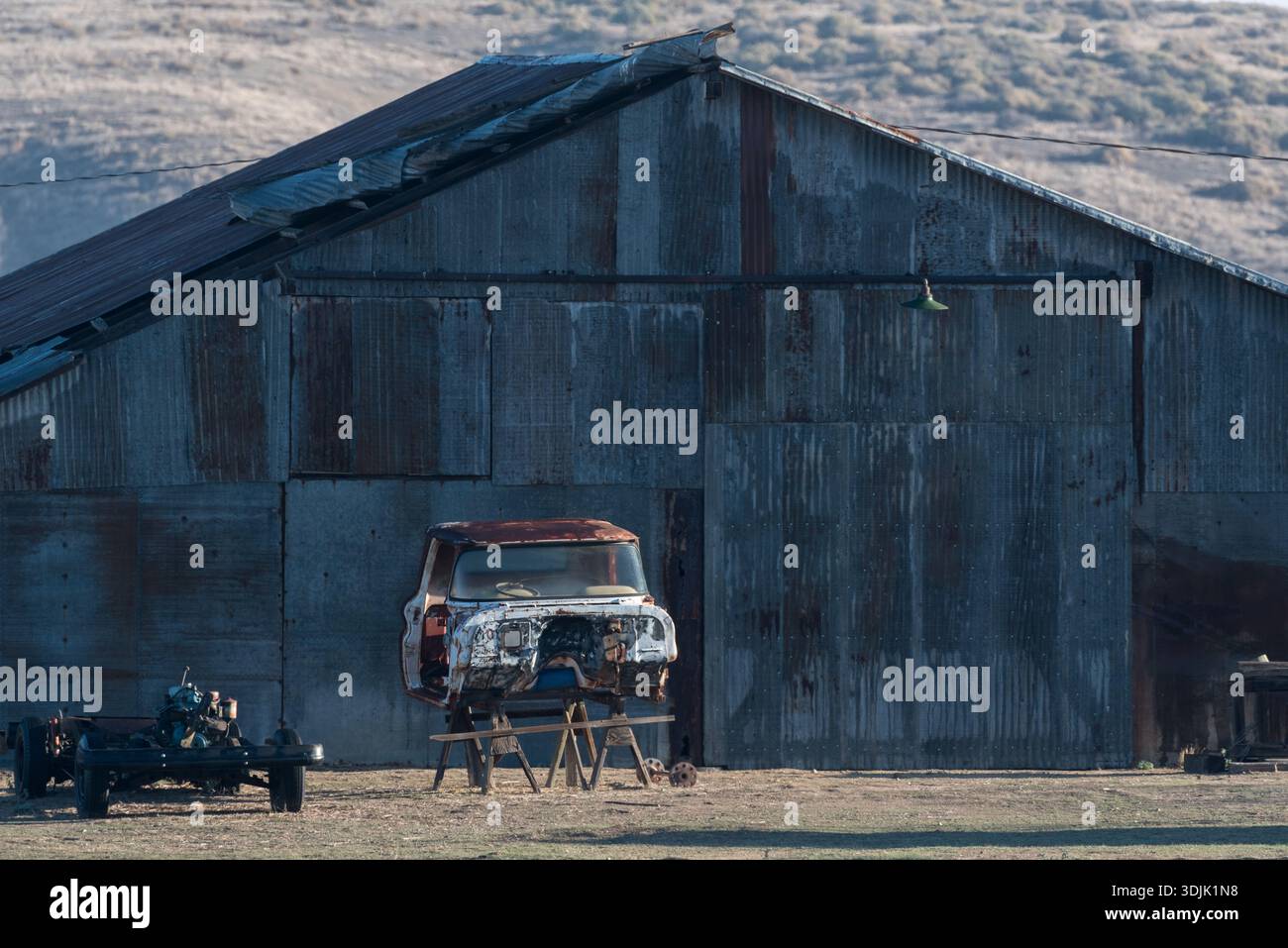 Cab of an old truck and a barn in rural Kern County, California, USA. Stock Photo