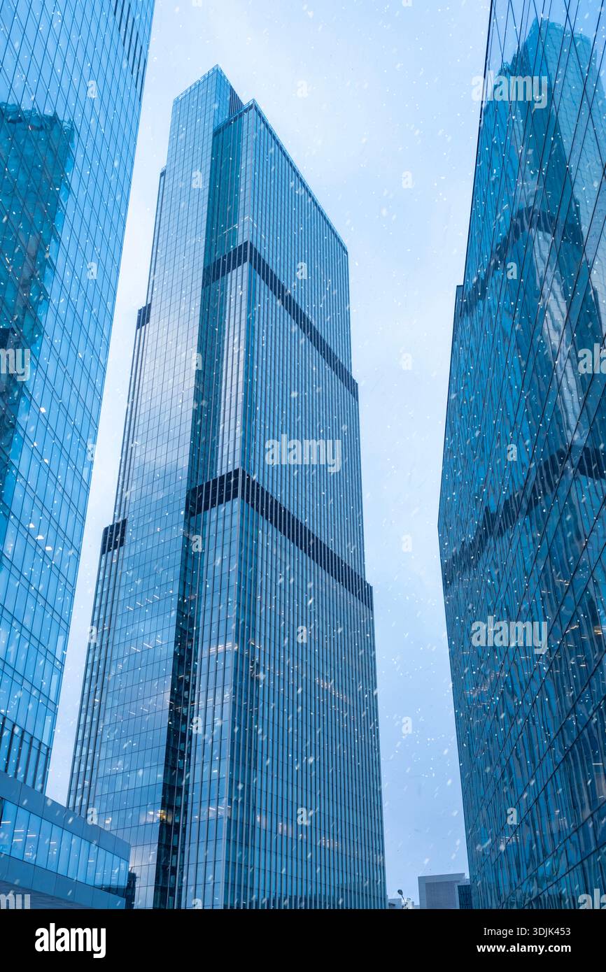 Moscow, Russia - January 18, 2022: Moscow-City is a business center in Moscow centre. The tops of modern corporate buildings in snowfall. Low angle vi Stock Photo