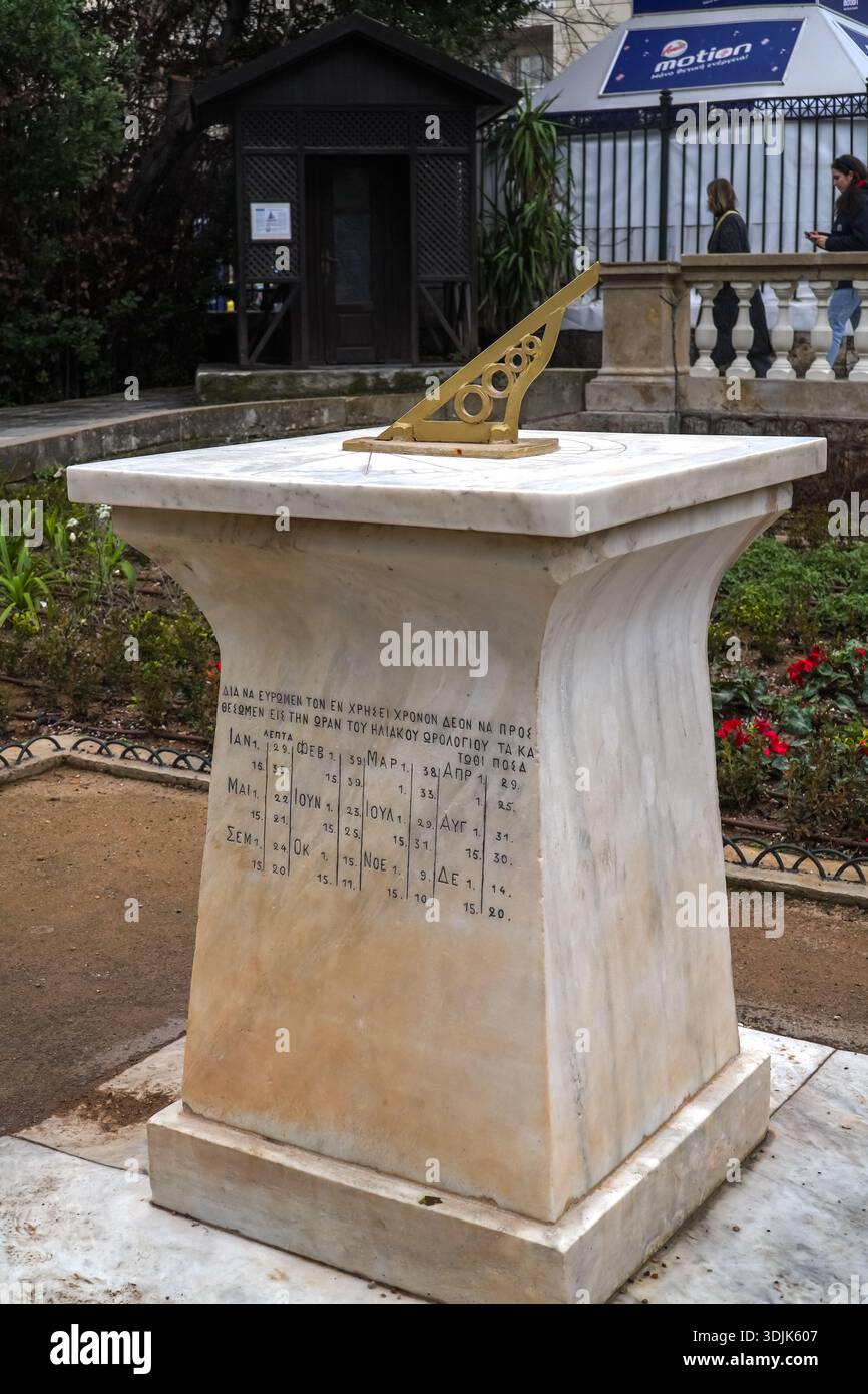 Horizontal sundial / solar clock with gold gnomon atop a white marble ...