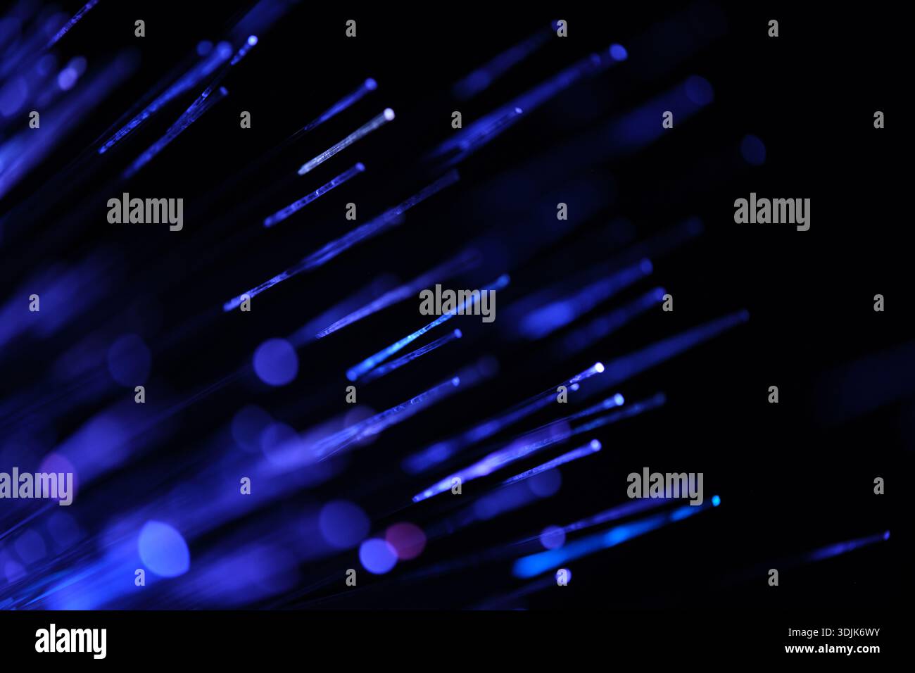 Fiber optical network cable in blue light on black background close up Stock Photo