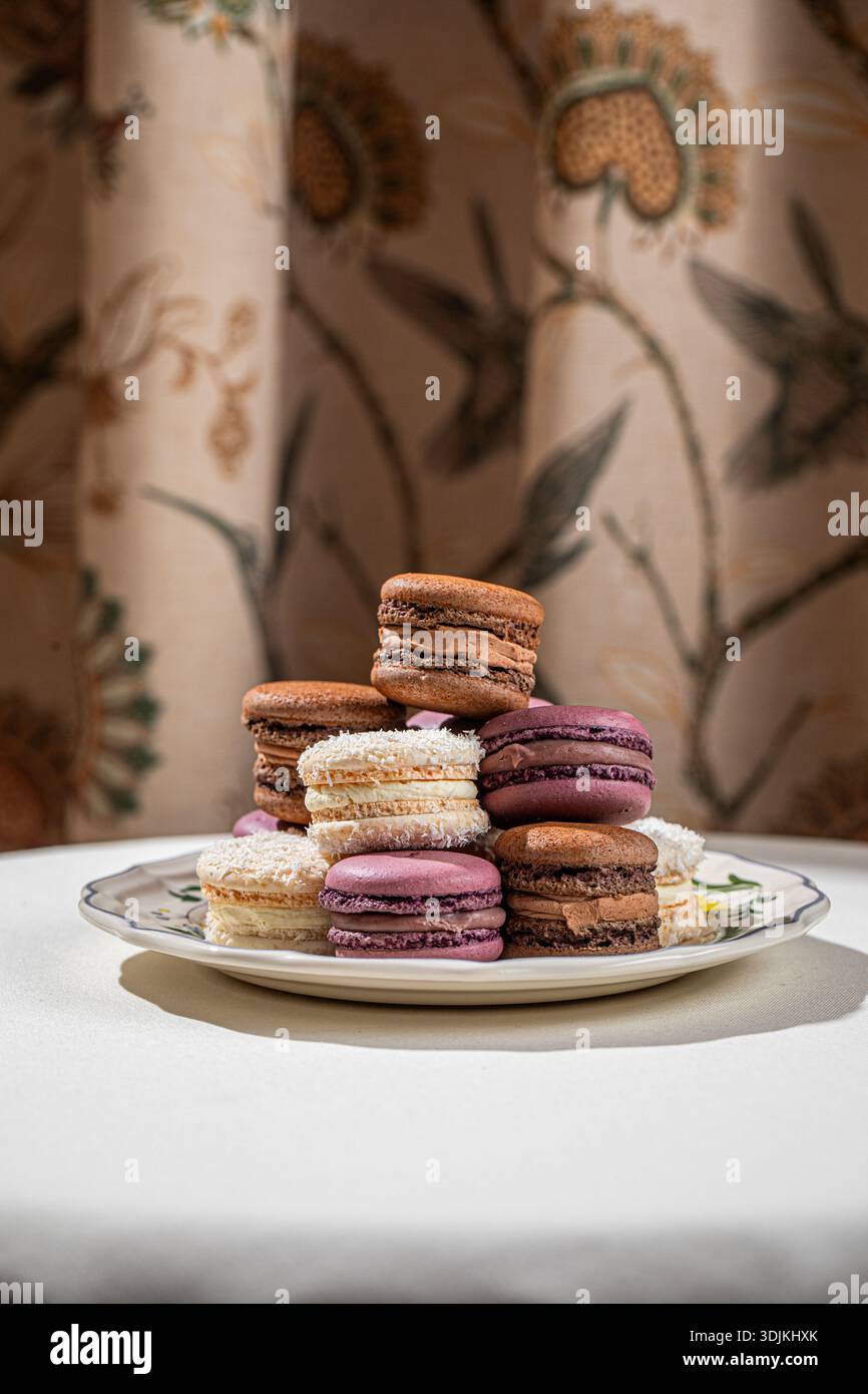 Assorted macarons stacked on decorative plate Stock Photo