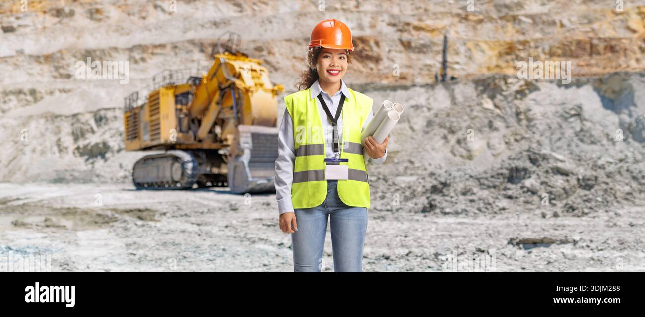 Female engineer holding blueprints at a mining site Stock Photo