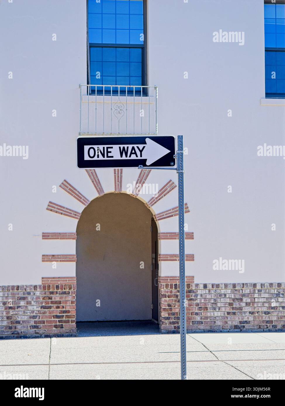 One way sign before arched entryway to building Stock Photo - Alamy