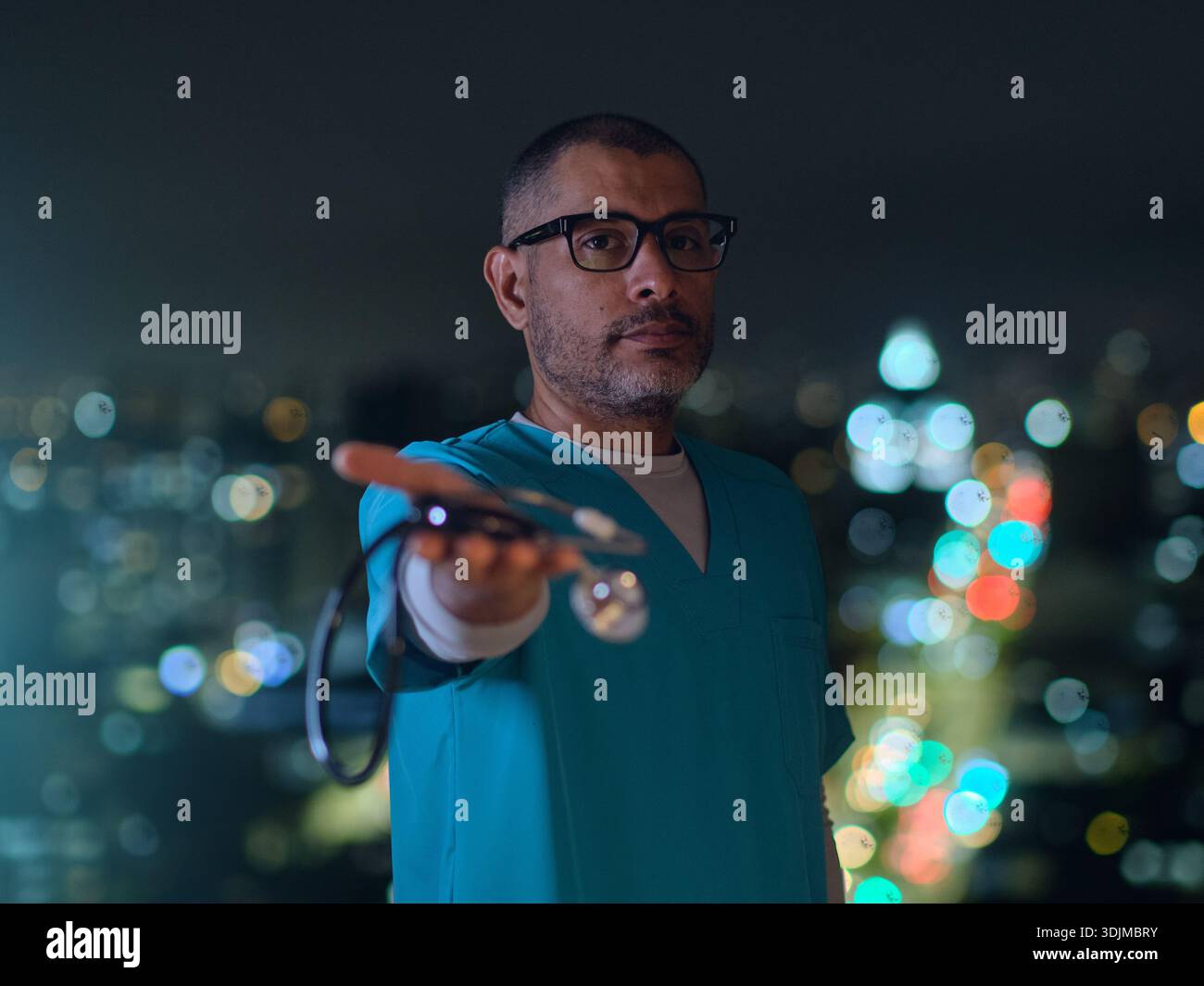 Medical professional offering a stethoscope with blurred city lights in the background Stock Photo