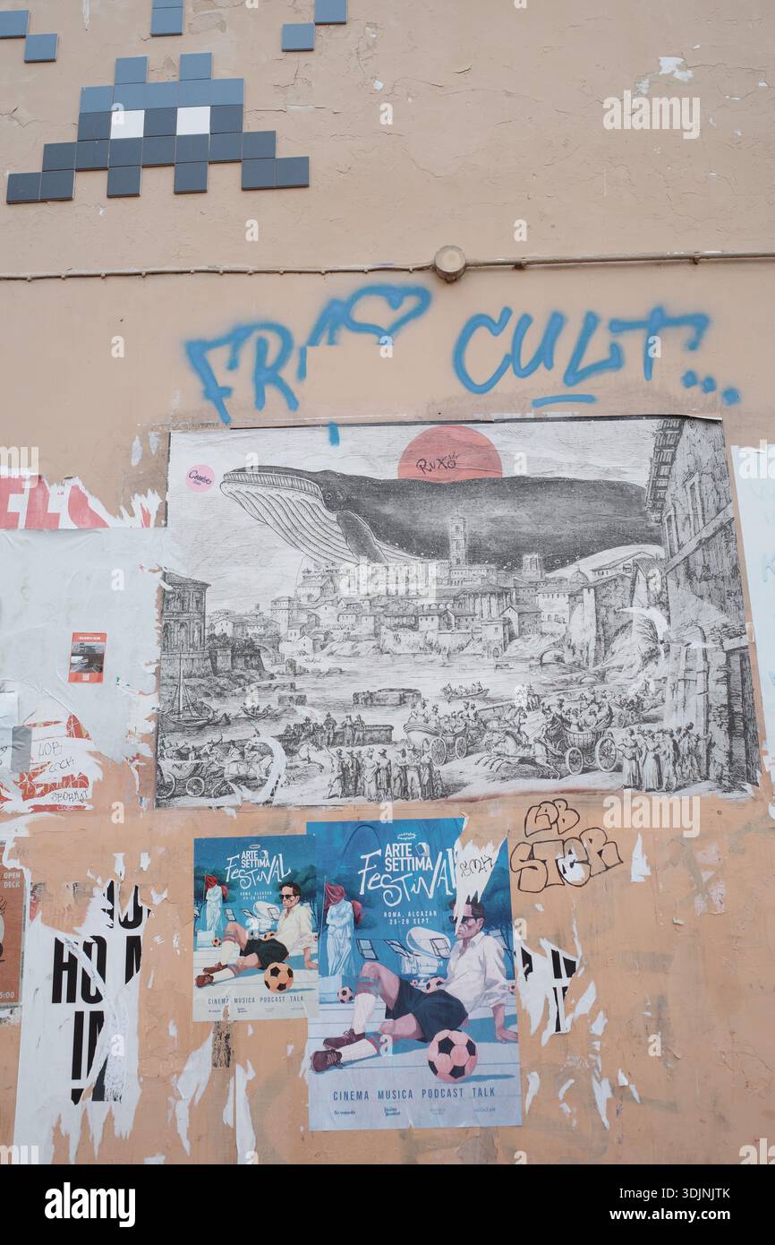 Street wall in Italy featuring various artworks and posters. Stock Photo