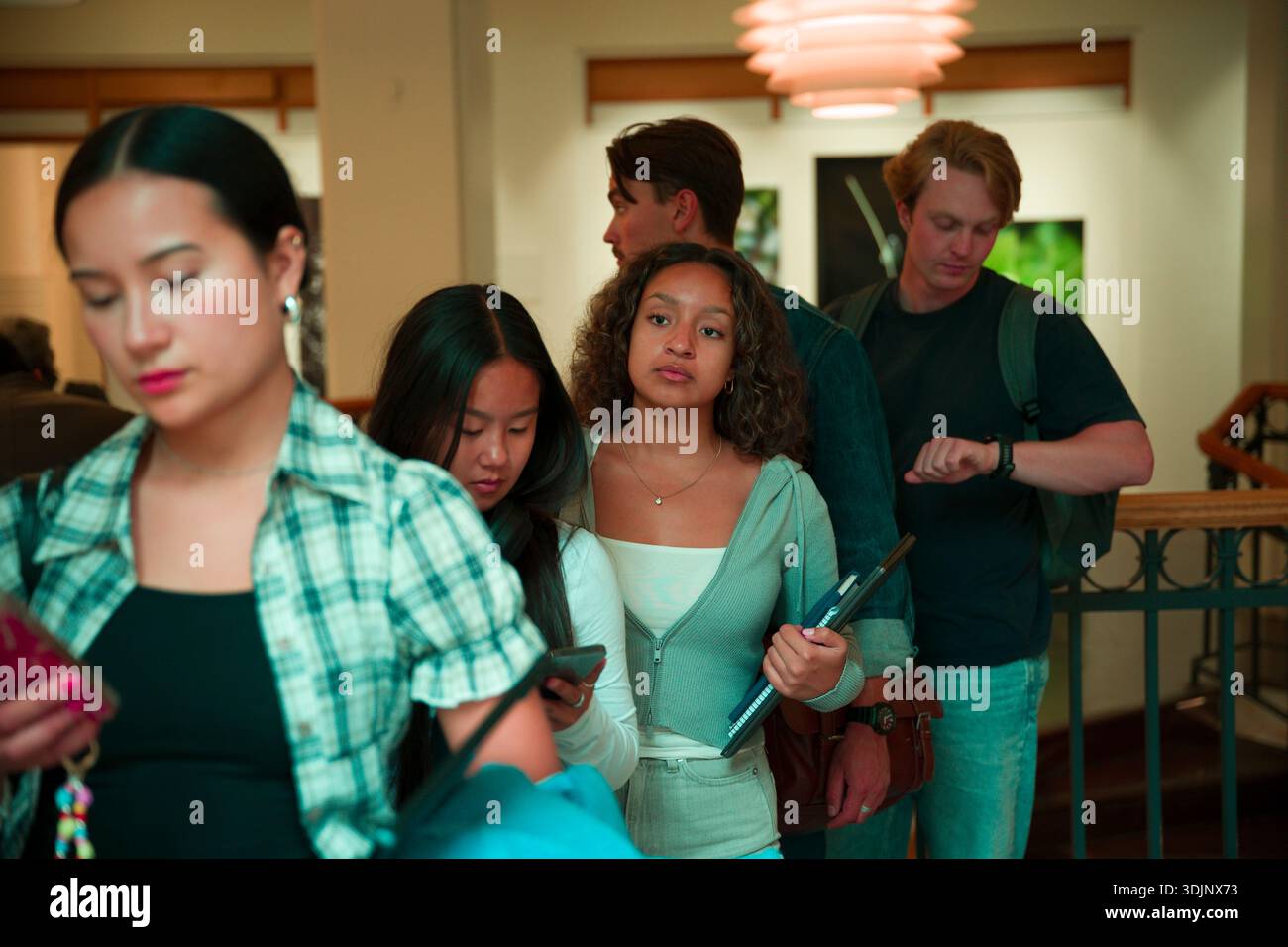 Young adult students waiting in line at college campus Stock Photo