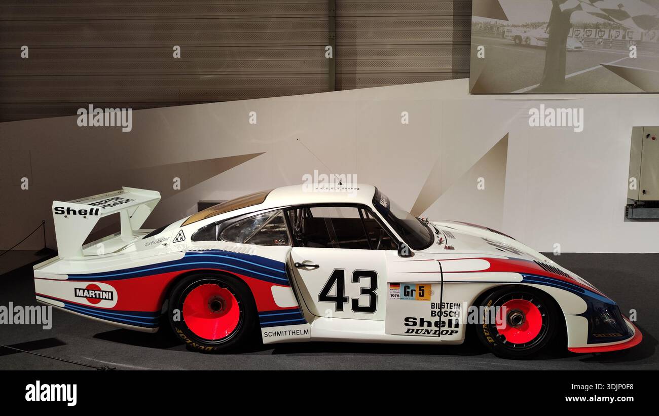 Side view of a historic white, orange and blue Martini Porsche 935