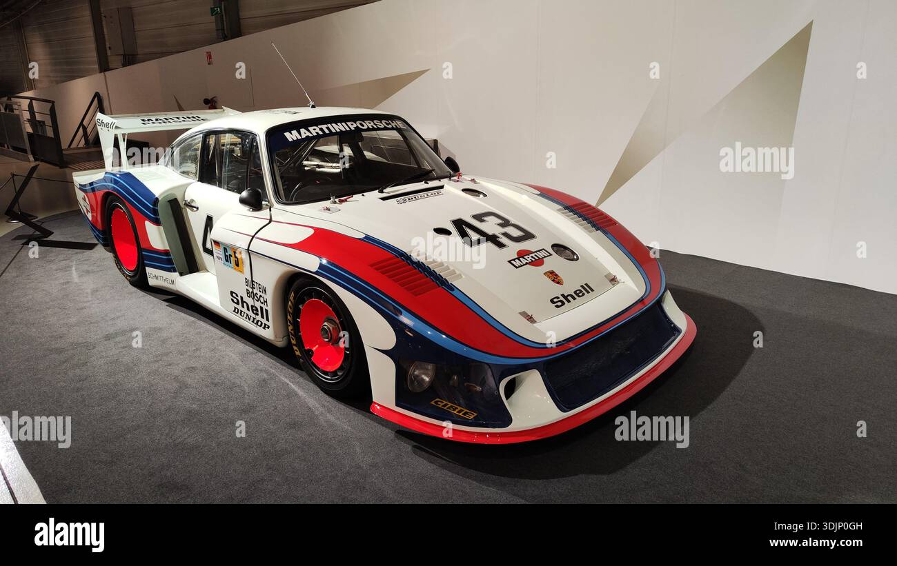 Front view of a historic white, orange and blue Martini Porsche