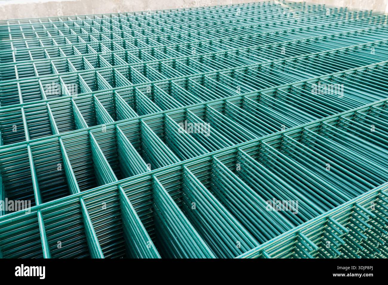Selective focus on metal lattice fencing modules with green rectangular cells. Stock Photo