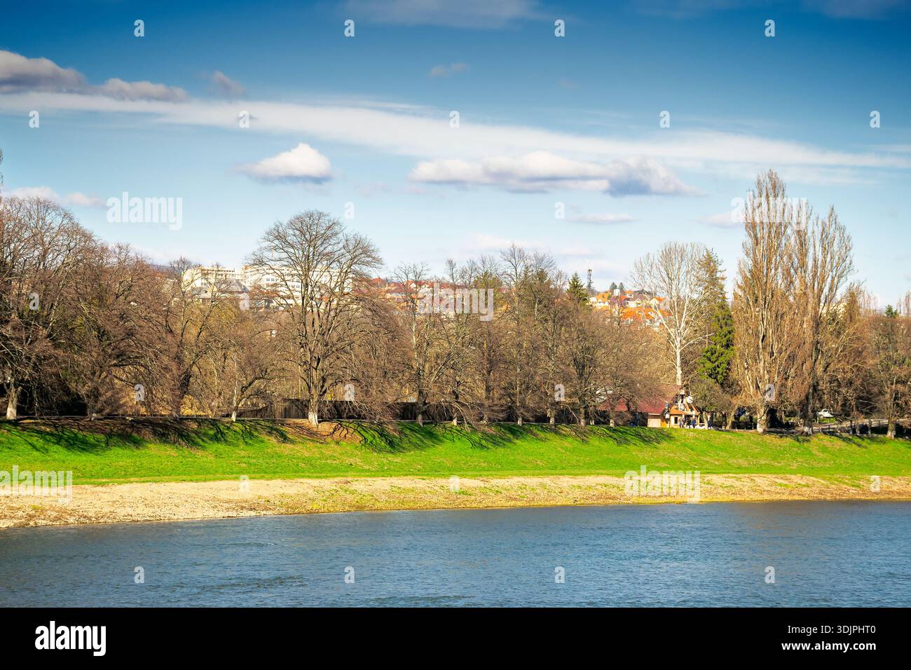 uzhhorod, ukraine - 14 mar 2016: river uzh on a sunny weather. ukrainian city embankment in spring. urban landscape of eastern europe with part of mas Stock Photo