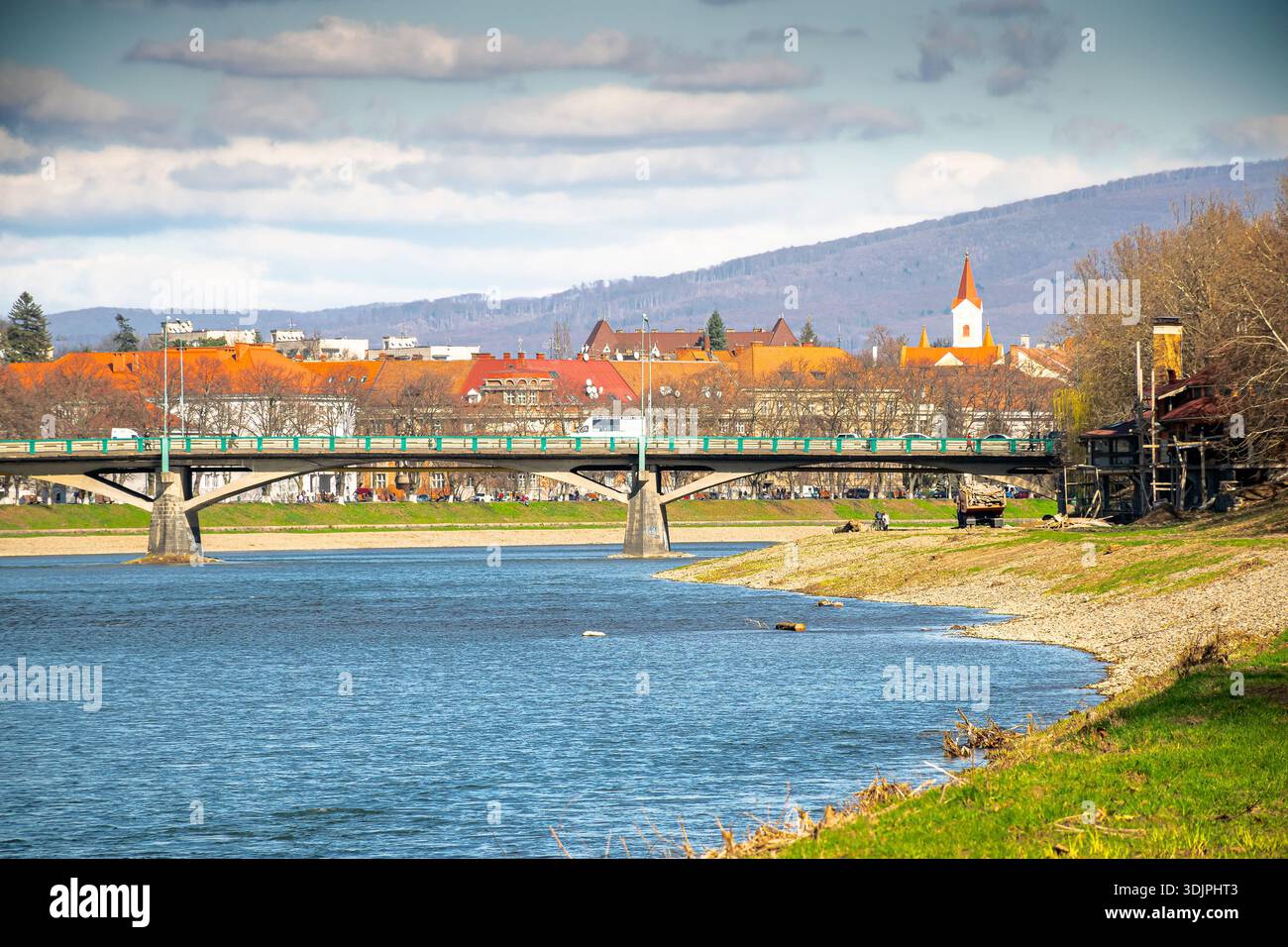 uzhhorod, ukraine - 14 mar 2016: river uzh on a sunny weather. ukrainian city embankment in spring. urban landscape of eastern europe with masaryk bri Stock Photo