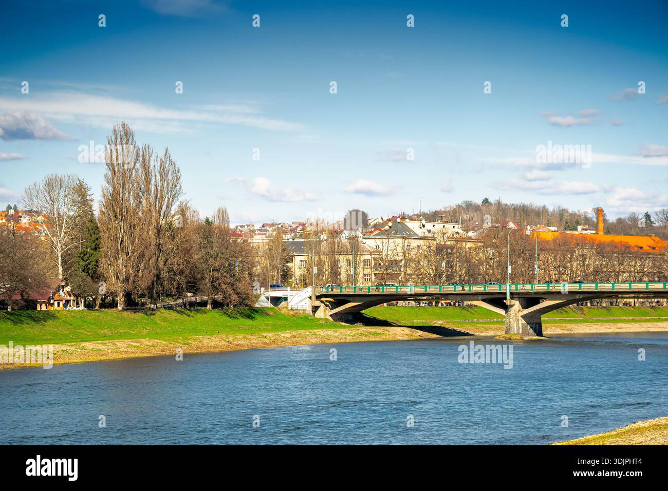 uzhhorod, ukraine - 14 mar 2016: river uzh on a sunny weather. ukrainian city embankment in spring. urban landscape of eastern europe with masaryk bri Stock Photo