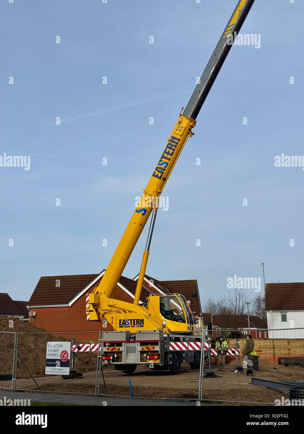 Kesgrave, Suffolk - 28 January 2026: Construction of a new Co Op supermarket in progess in the Grange Farm area. Tall crane looms over nearby houses. - Smartphone Captured Stock Image