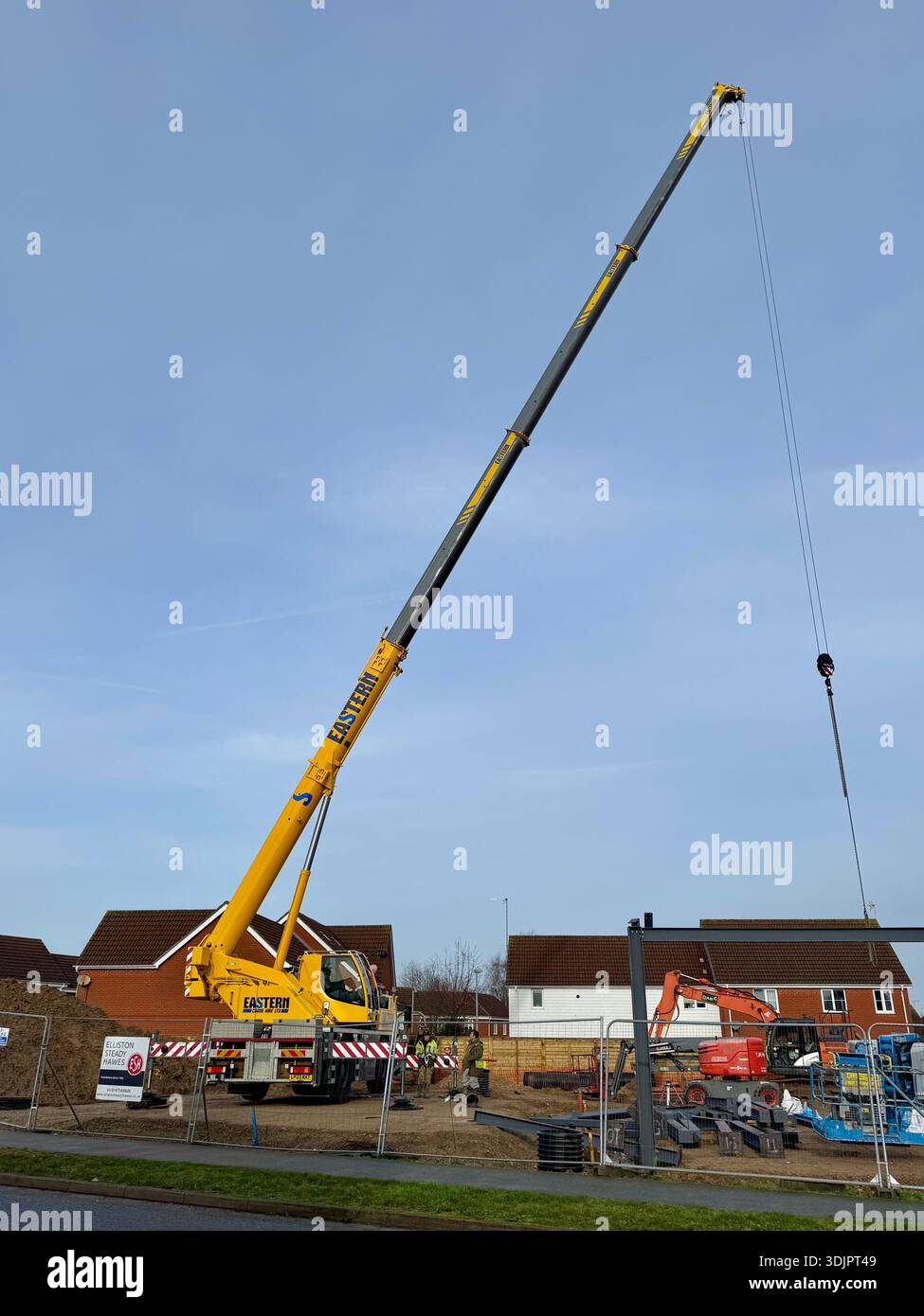 Kesgrave, Suffolk - 28 January 2026: Construction of a new Co Op supermarket in progess in the Grange Farm area. Tall crane looms over nearby houses. - Smartphone Captured Stock Image