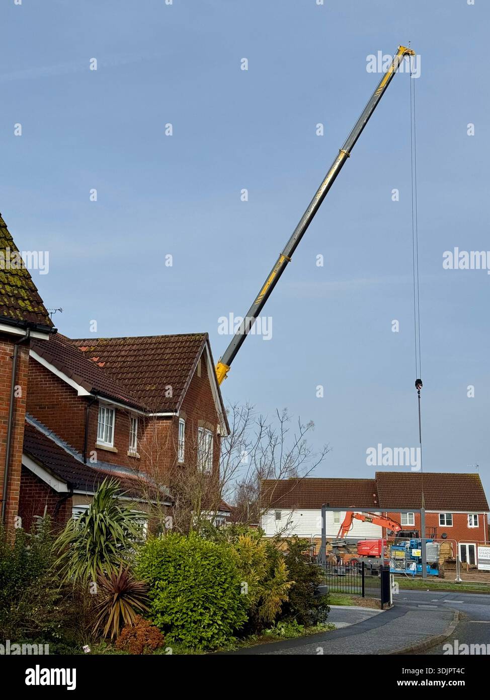 Kesgrave, Suffolk - 28 January 2026: Construction of a new Co Op supermarket in progess in the Grange Farm area. Tall crane looms over nearby houses. - Smartphone Captured Stock Image