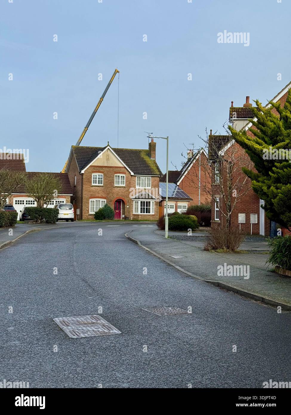 Kesgrave, Suffolk - 28 January 2026: Construction of a new Co Op supermarket in progess in the Grange Farm area. Tall crane looms over nearby houses. - Smartphone Captured Stock Image