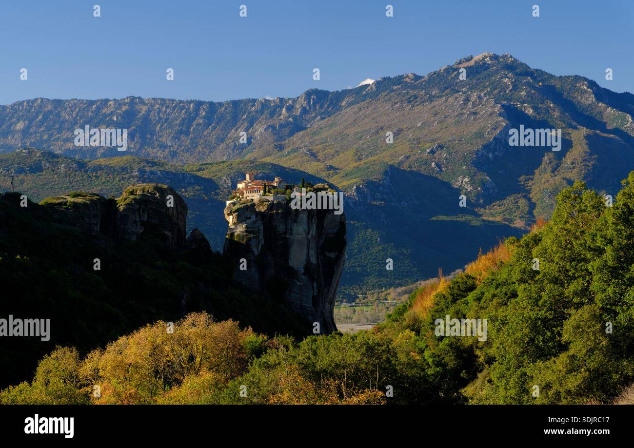 Monastery of the Holy Trinity perched on a dramatic rock pillar in Meteora with mountain landscape in autumn, Thessaly, Greece Stock Photo