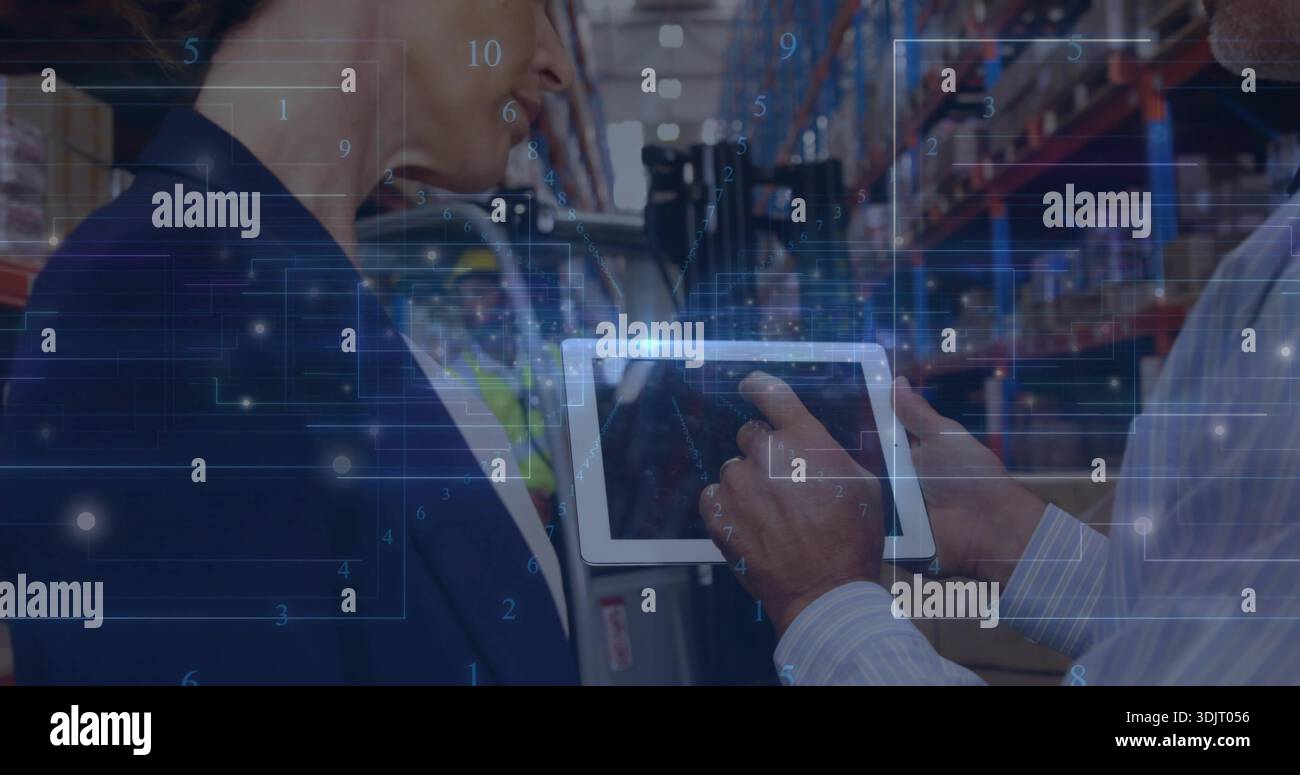 Checking tablet, worker reviewing logistics in warehouse aisle, showing HUD, blazer, vest, hard hat Stock Photo