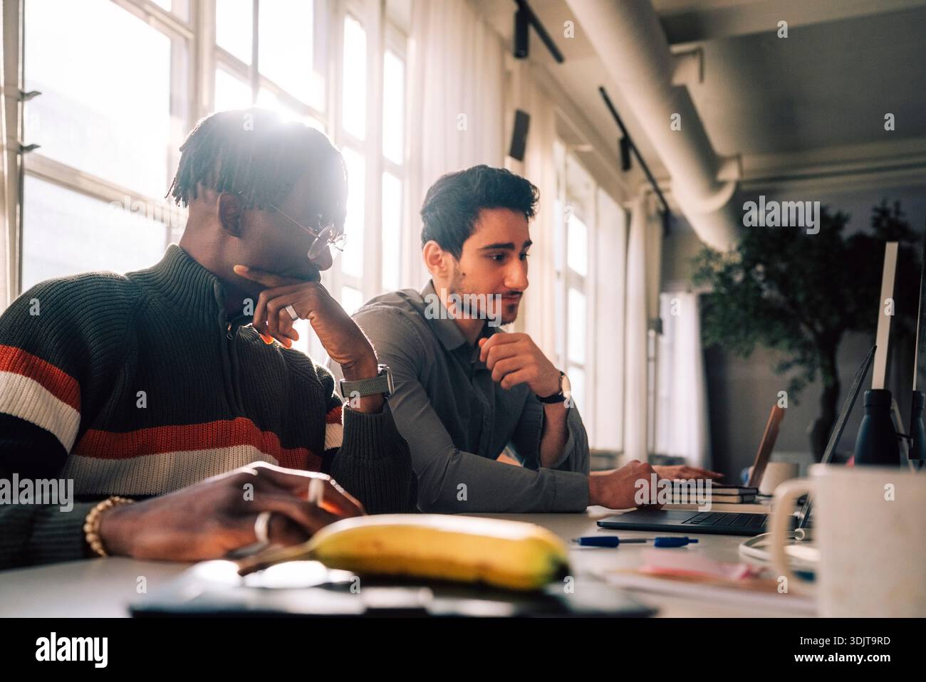 Focused male tech professionals working in office Stock Photo