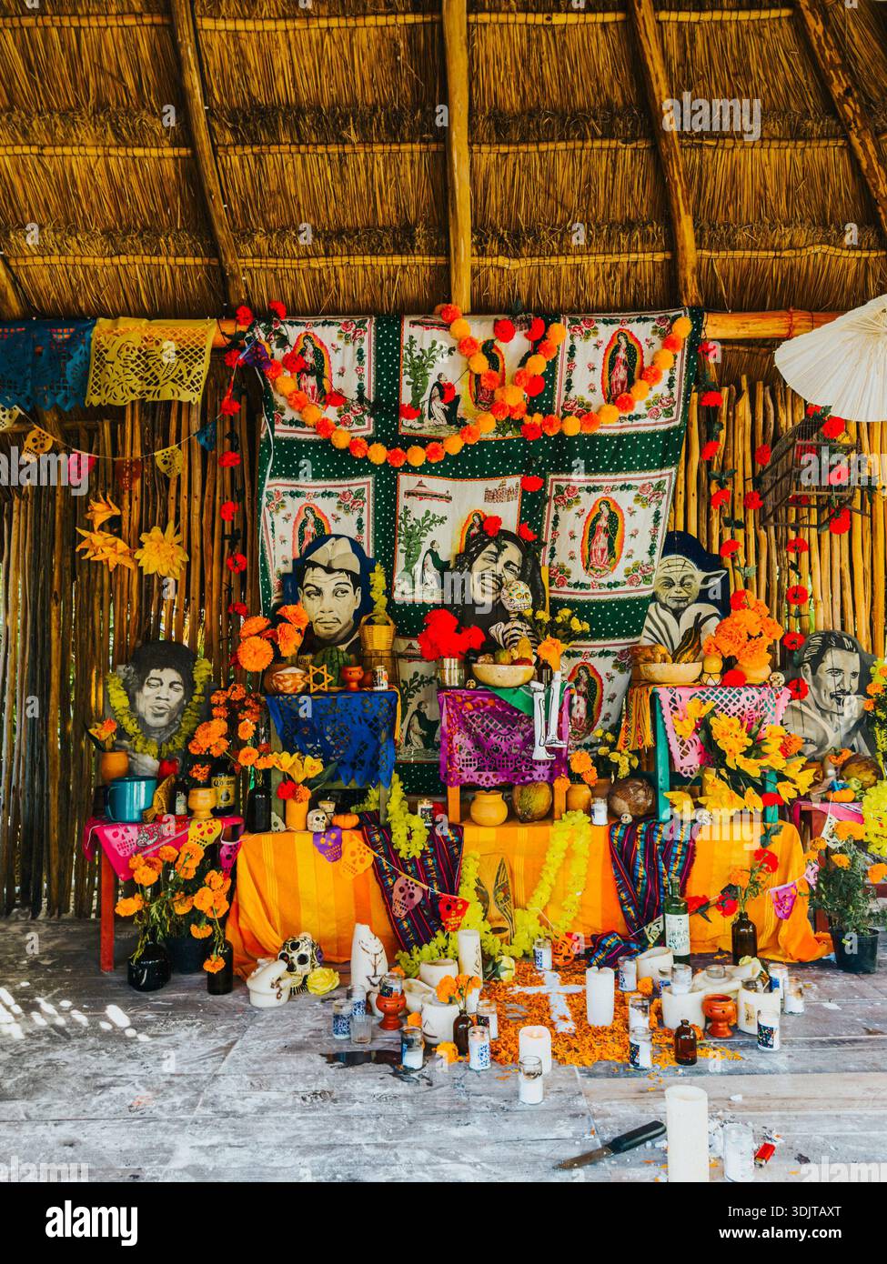 Traditional Day of the Dead altar adorned with marigolds, candles, sugar skulls, and iconic figures in Tulum, Mexico. Stock Photo