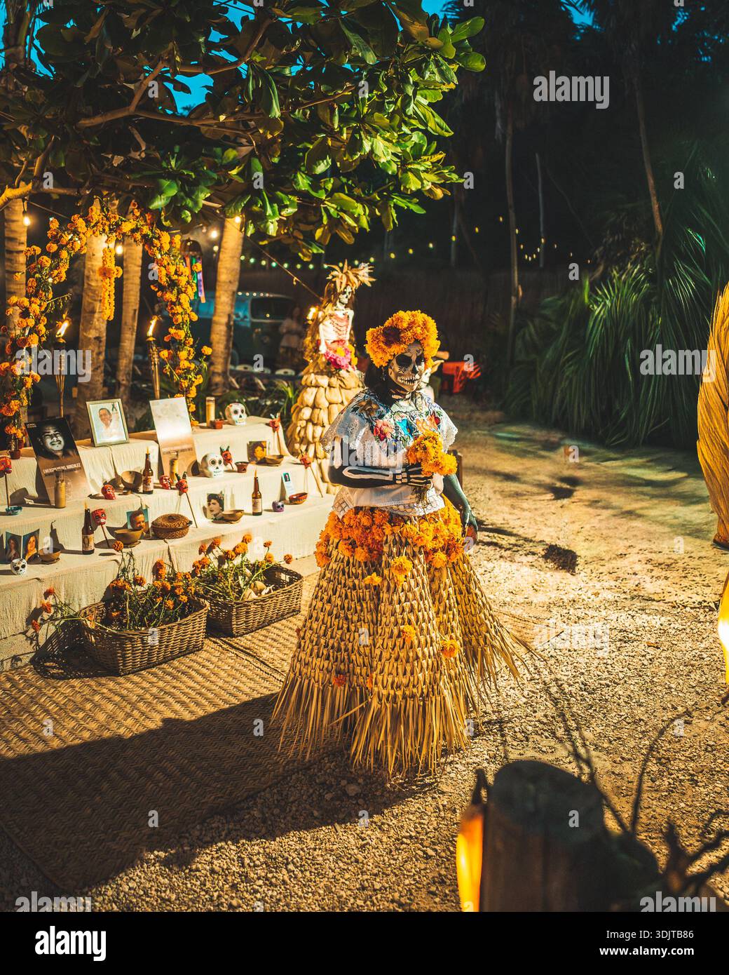 Catrina-style Day of the Dead person dressed in traditional attire beside a ceremonial altar in Tulum, Mexico. Stock Photo