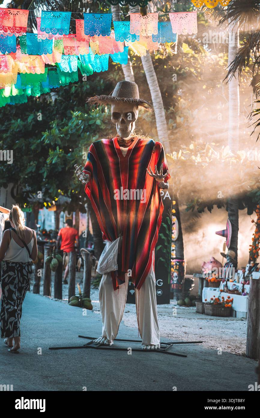 Life-size skeleton figure dressed in traditional clothing displayed on a street in Tulum, Mexico during Day of the Dead celebrations. Stock Photo