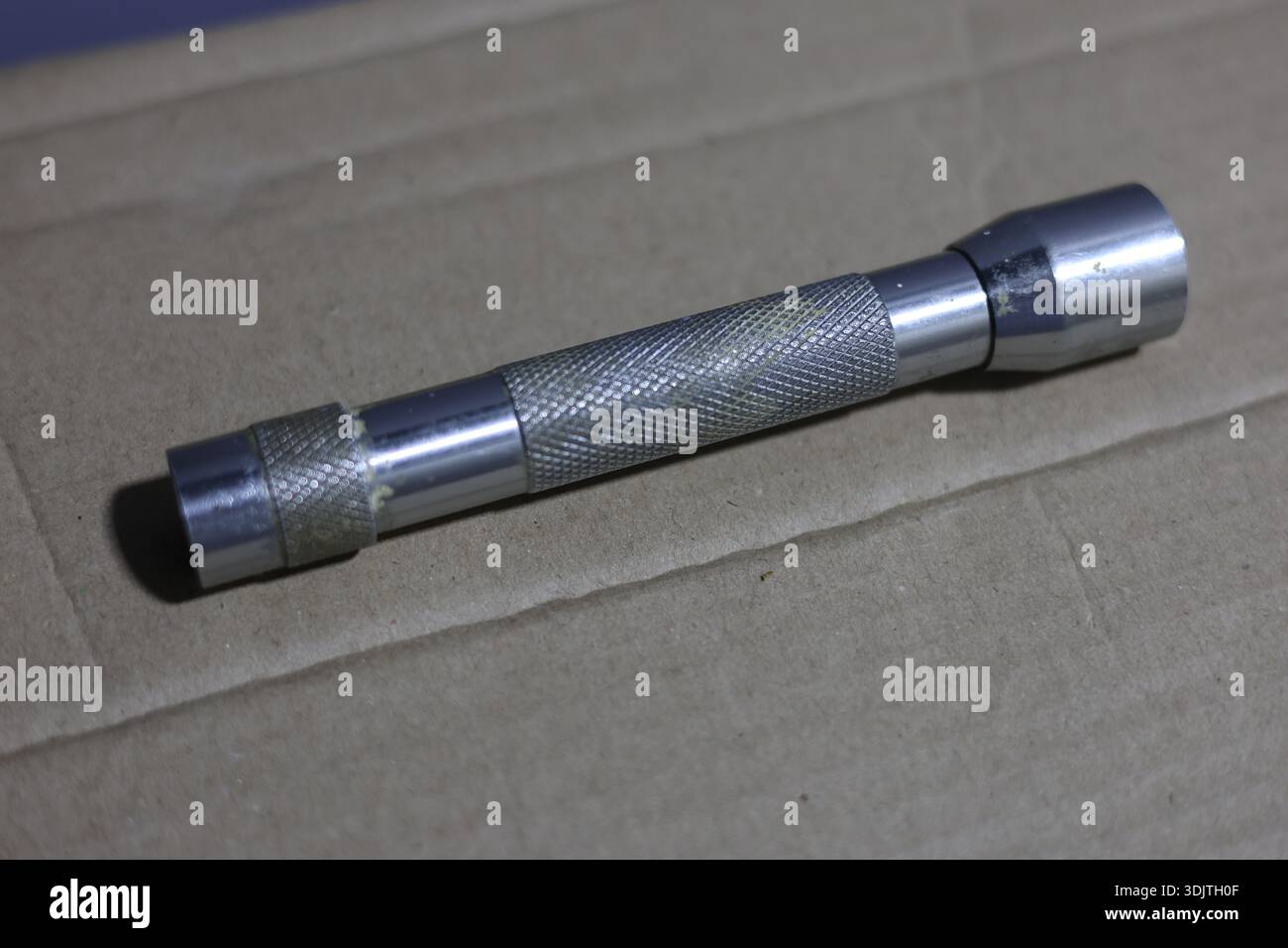 A small metallic used and dirty flashlight Stock Photo