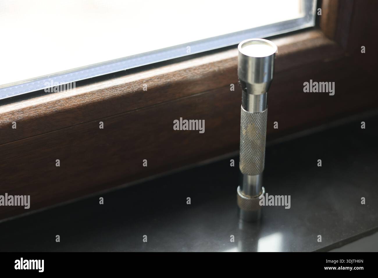 A small metallic used and dirty flashlight Stock Photo