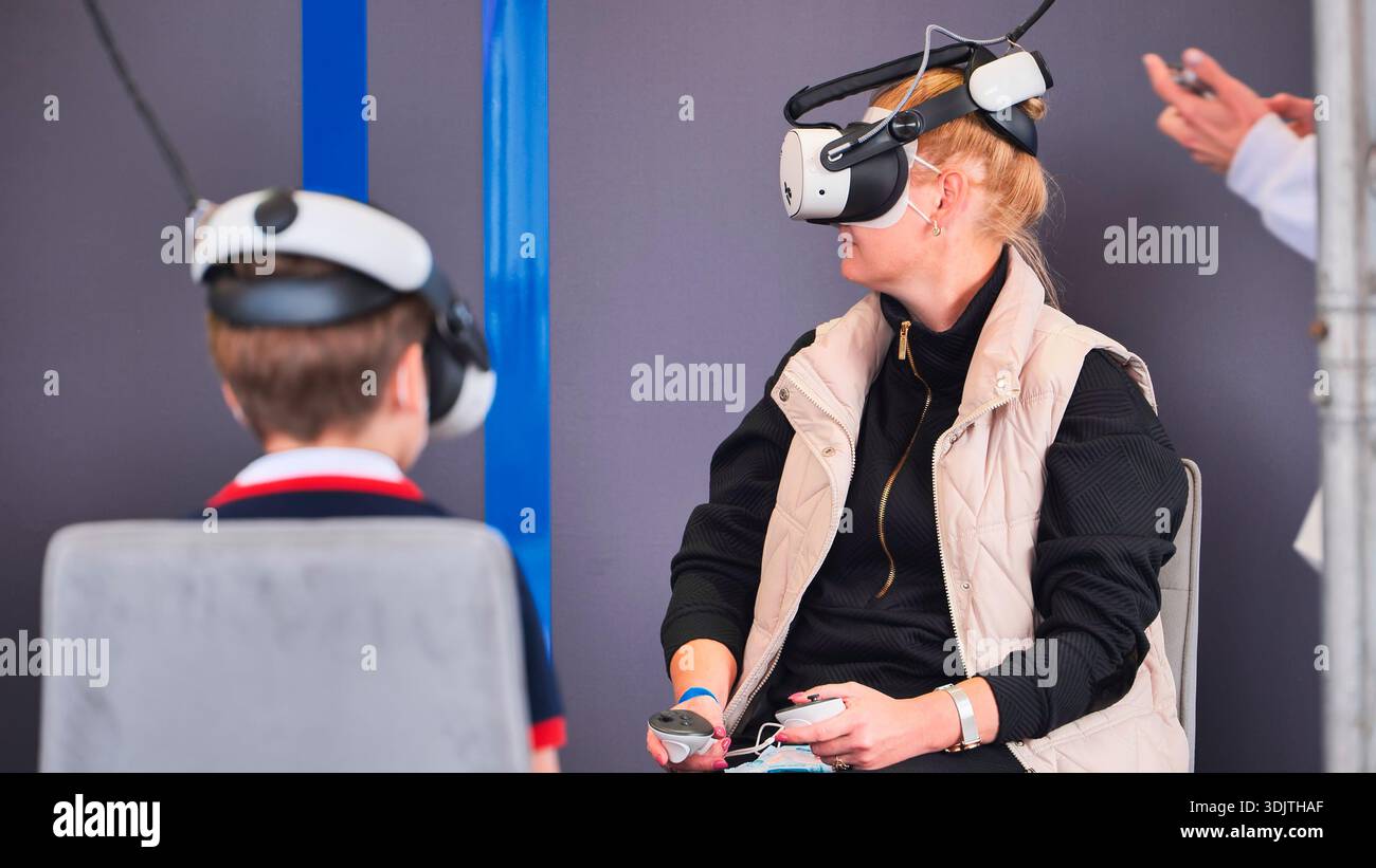 People experiencing immersive virtual reality gaming and simulation ...
