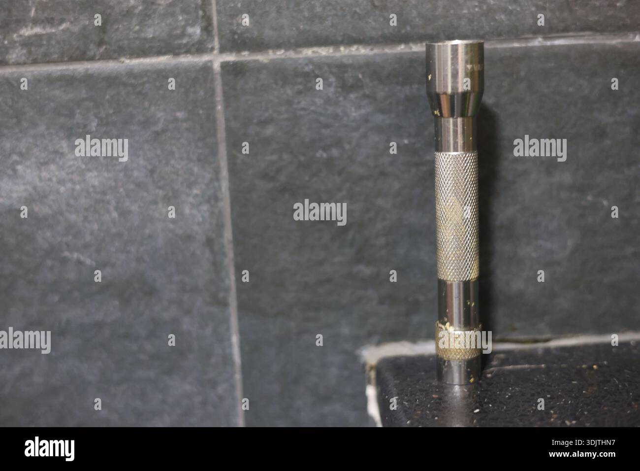 A small metallic used and dirty flashlight Stock Photo