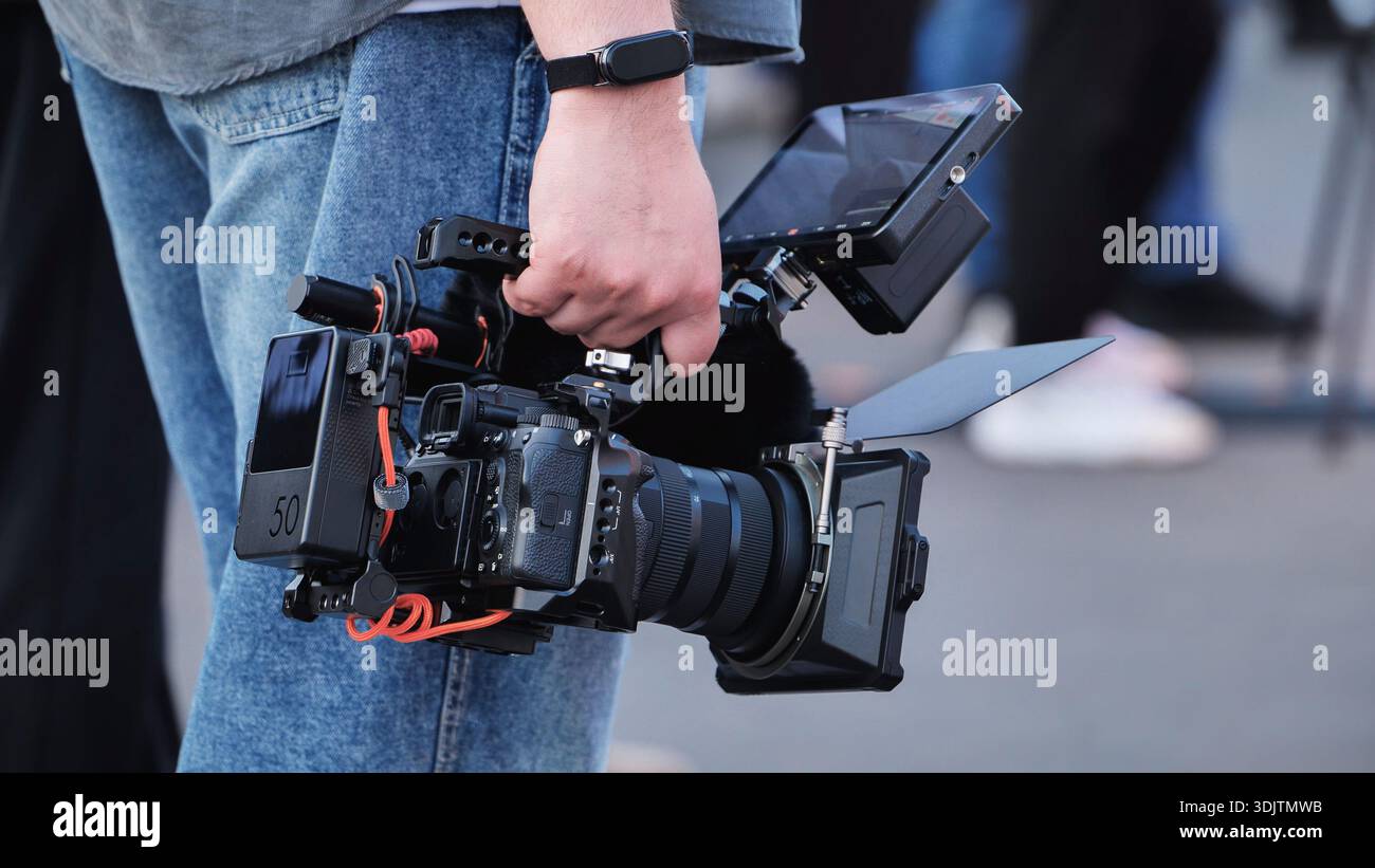 Videographer holding professional cinema camera rig filming production Stock Photo
