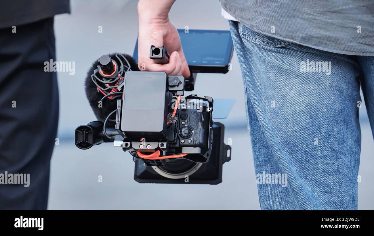 Videographer holding a professional video camera and full cinema rig Stock Photo