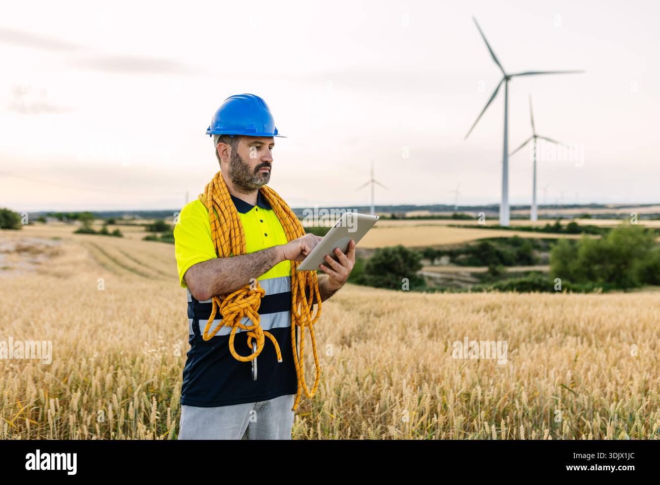 Engineer using tablet checking wind turbine farm Stock Photo