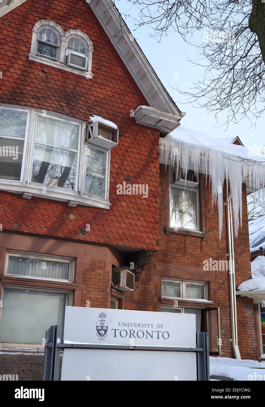 Old building at the University of Toronto with icicles hanging from the eaves Stock Photo