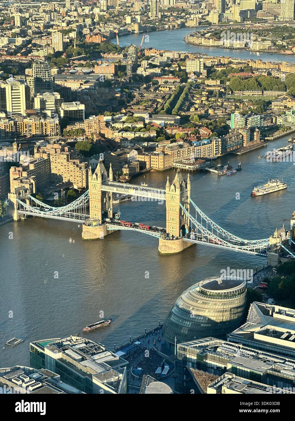 High-angle view of Tower Bridge over the River Thames, photographed from The Shard, showing London cityscape, City Hall, and river traffic in daylight - Smartphone Captured Stock Image