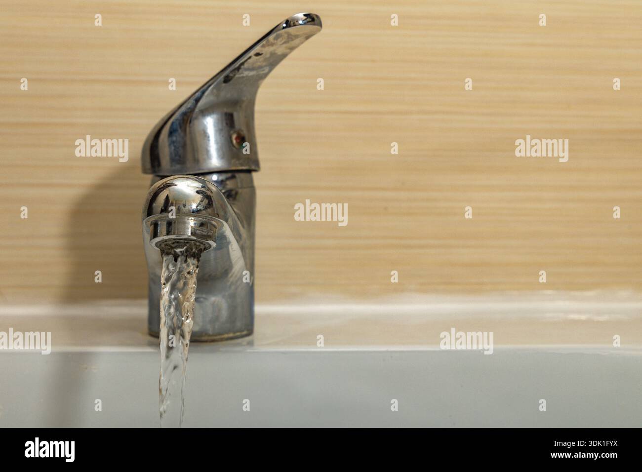 Water leaking from the tap into the sink, dripping clean water, data ...