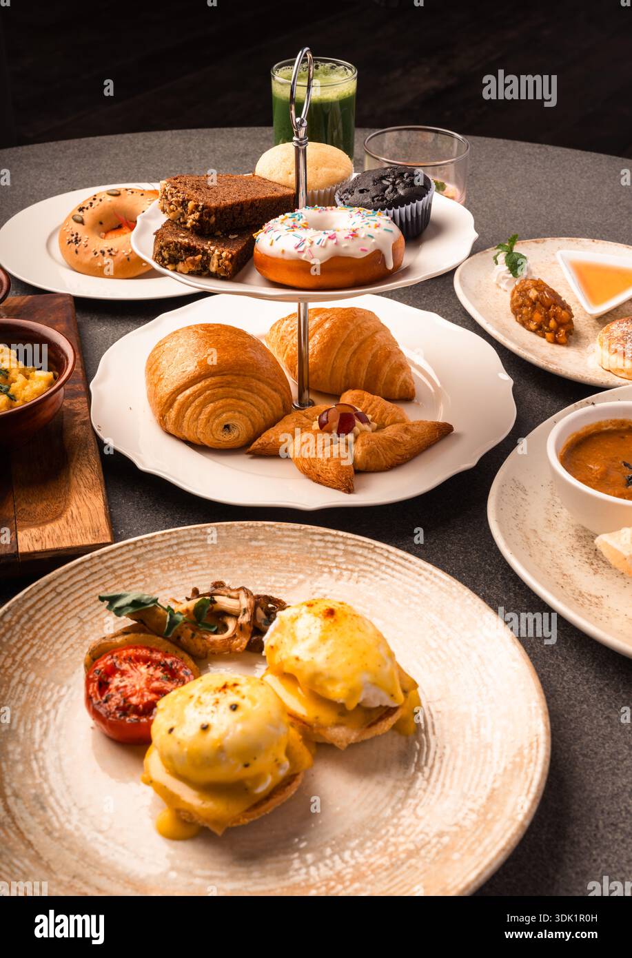 Elaborate Breakfast Spread with Eggs Benedict and Pastries Stock Photo