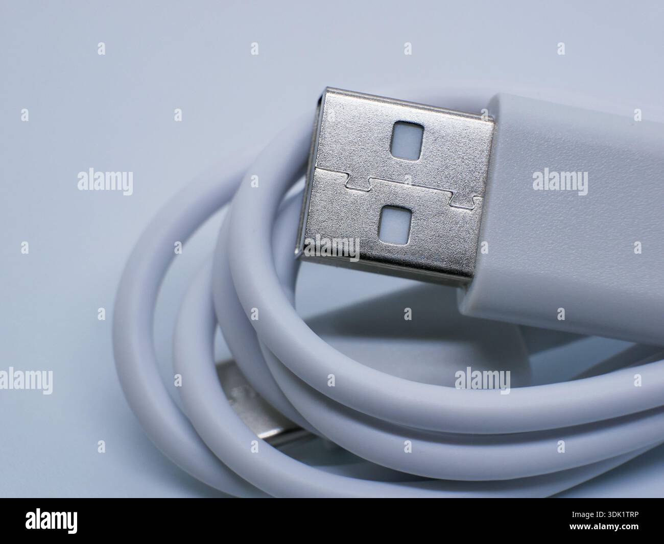 Close-up of white USB cable with connector on clean white background. Charging and data transfer concept for smartphones, gadgets, accessories, techno Stock Photo
