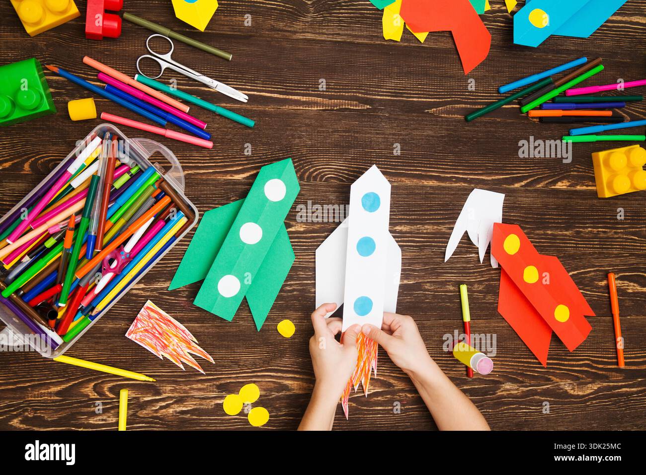 preschool Child in creativity in the home. Happy kid makes rockets from ...