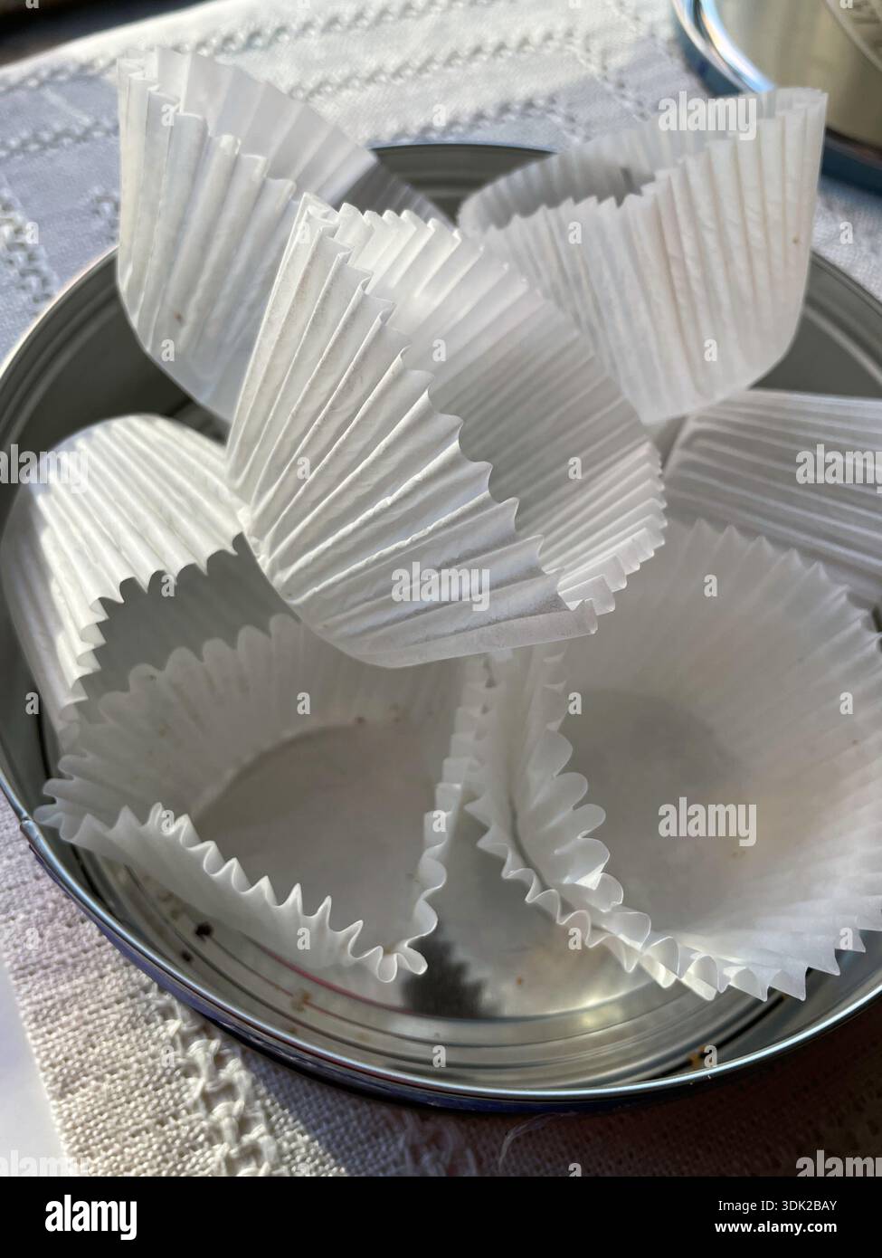 Still life of fluted paper cups in an empty cookie tin, United States - Smartphone Captured Stock Image