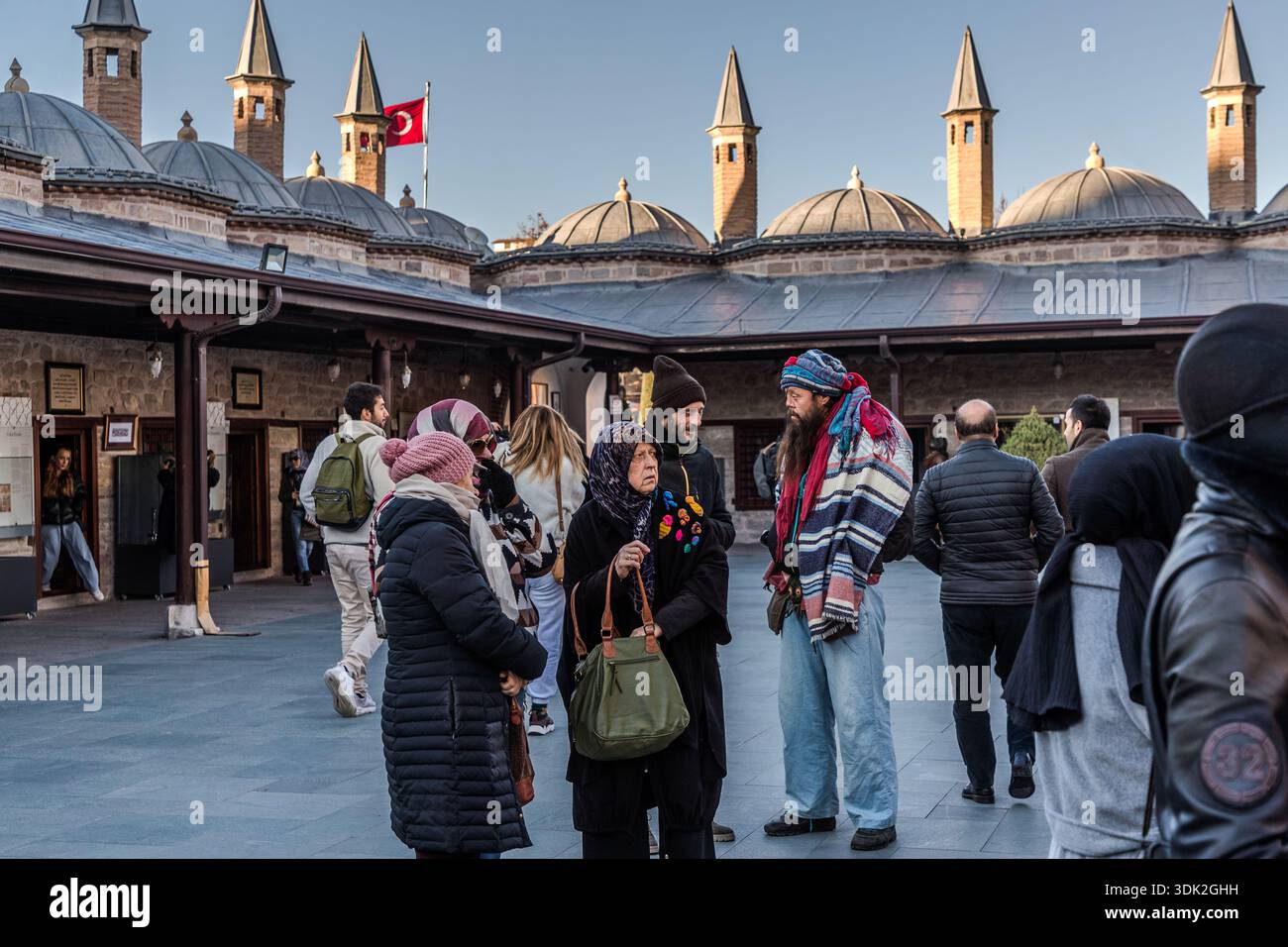 The Mevlana Museum (Mevlânâ Müzesi) in Konya's Karatay district, Turkey, draws an international audience in front of the mausoleum of Jalāl ad-Dīn ar-Rūmī. The museum is the mausoleum of the Sufi mystic Rumi (1207–1273), with an adjoining mosque and former dervish lodge; the turquoise dome built over his grave in 1274 is considered a symbol of Konya. 17 December, the anniversary of Rumi's death, is also the day of the annual Şeb-i Arus festival, whose celebrations have gathered the visitors here. Stock Photo