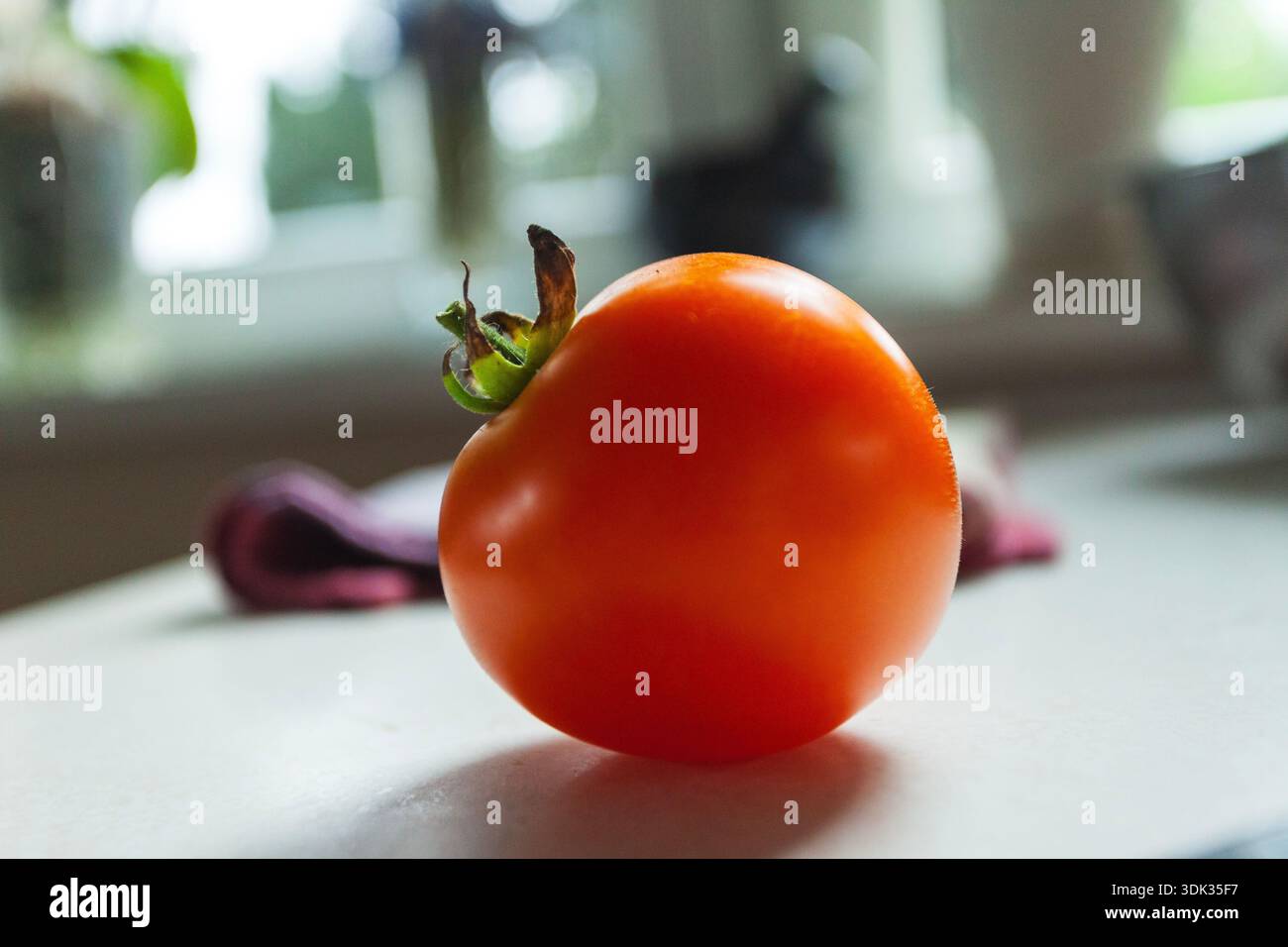 The red tomato is on the counter Stock Photo