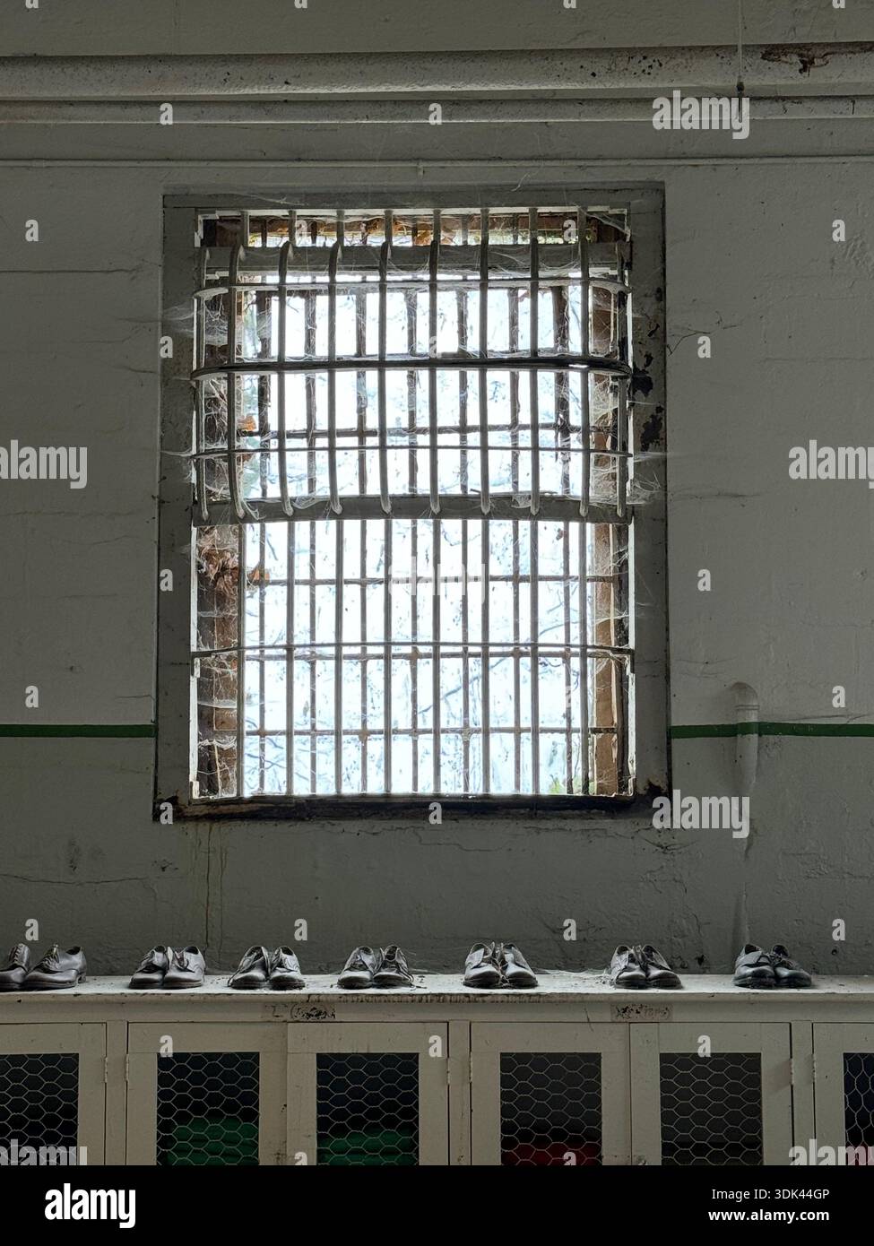 Window Cell Barred window in prison cell with shoes lined below, symbolic ...