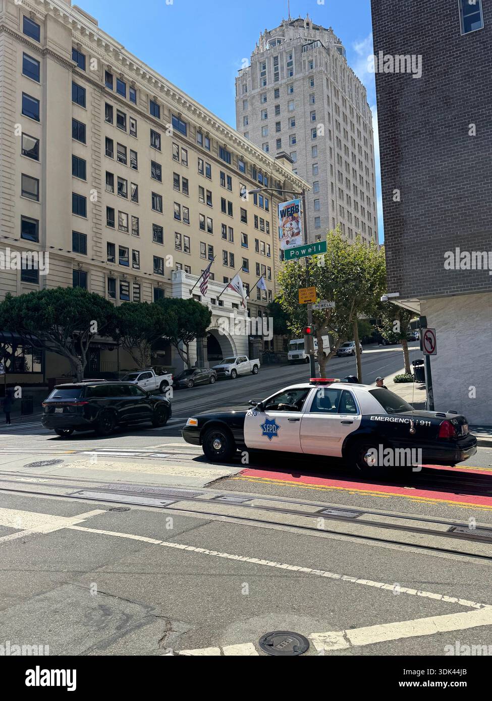 San Francisco police car parked on a steep downtown street with historic buildings in the background. - Smartphone Captured Stock Image