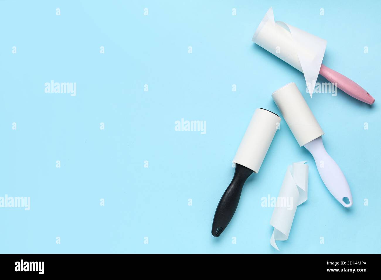 Sticky lint rollers on blue background Stock Photo