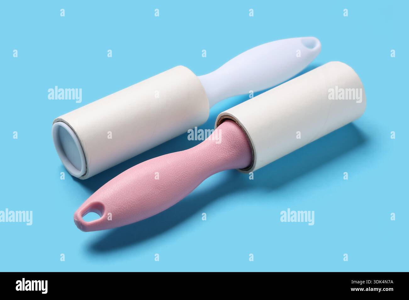 Sticky lint rollers on blue background Stock Photo