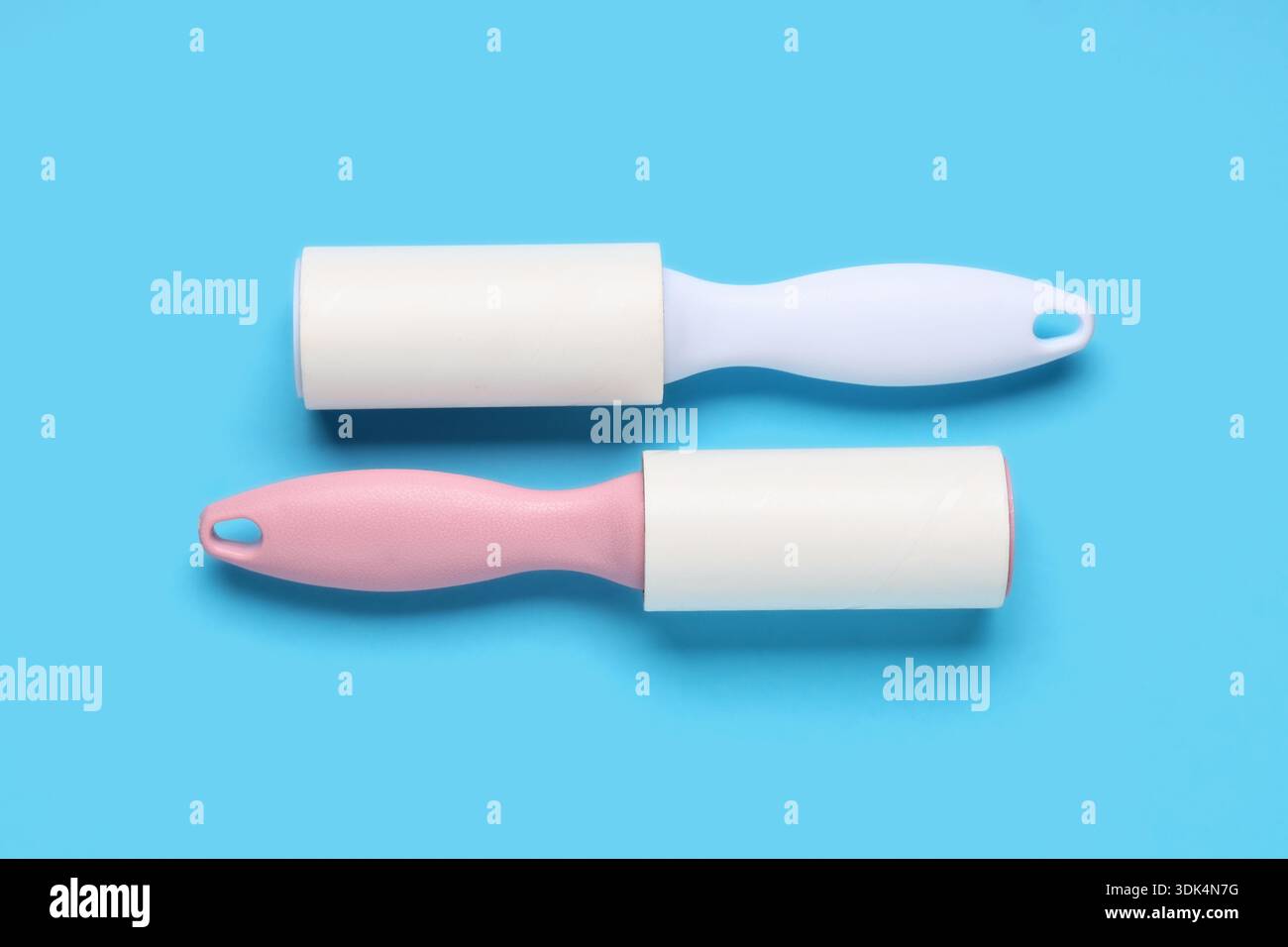 Sticky lint rollers on blue background Stock Photo