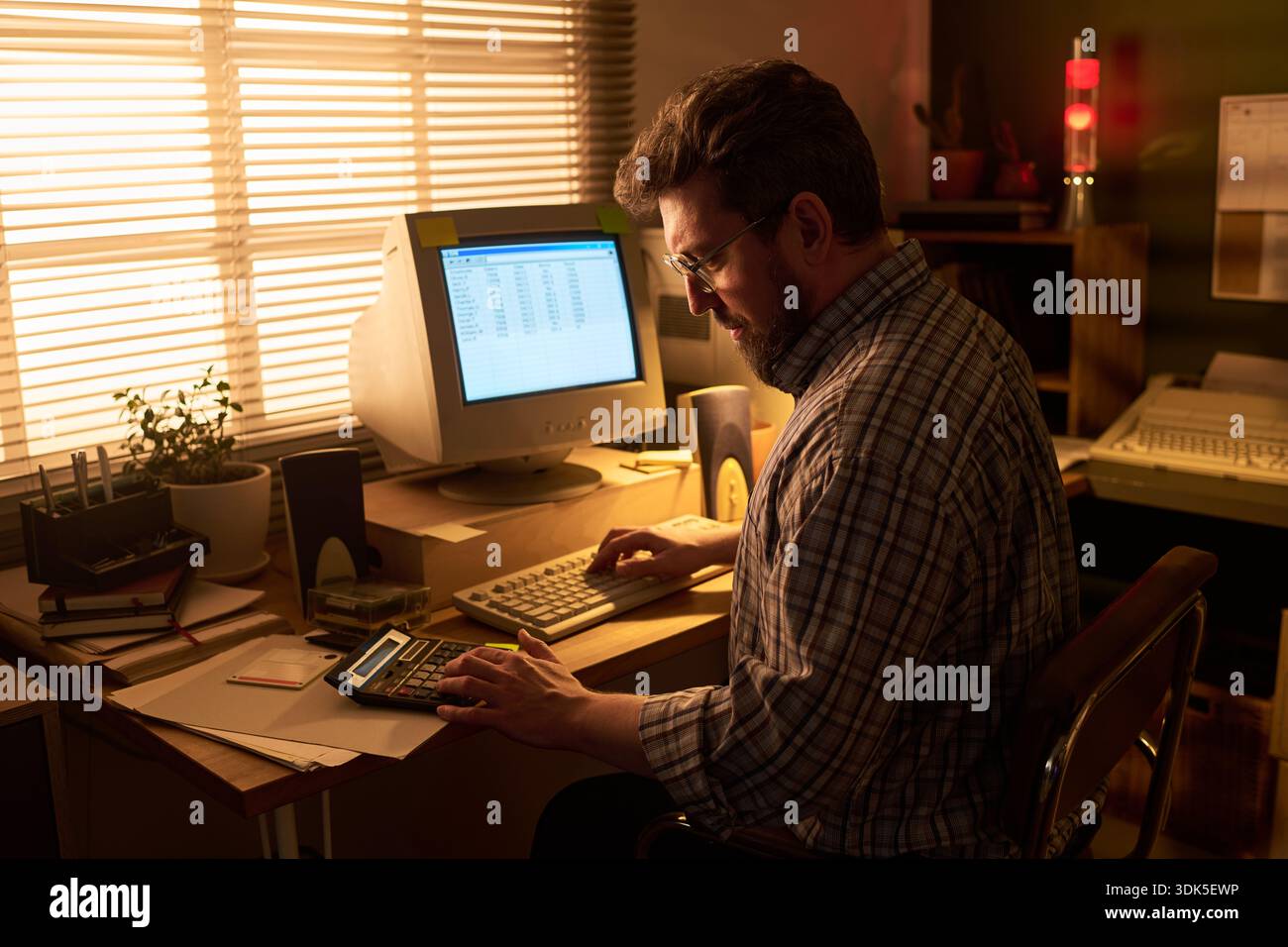 Data Entry Computer Desk Caucasian man working at desk using vintage computer and calculator ...